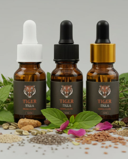 Three brown glass bottles with droppers on a white surface with green leaves and herbs.